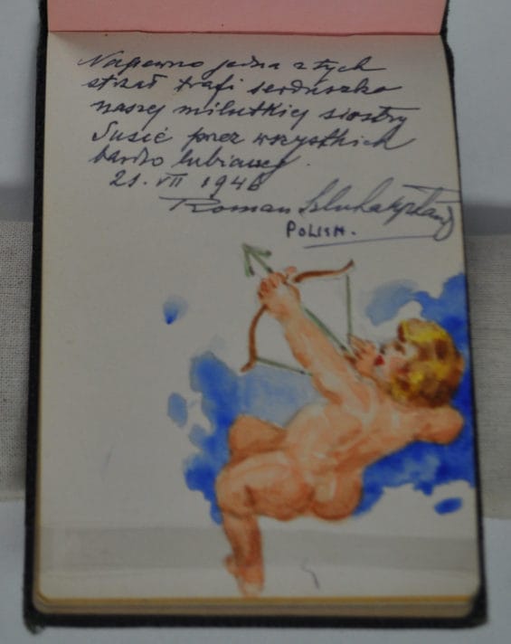 Page in autograph notebook with a small message written in Polish and a watercolour painting of a naked cupid firing a bow and arrow upwards.