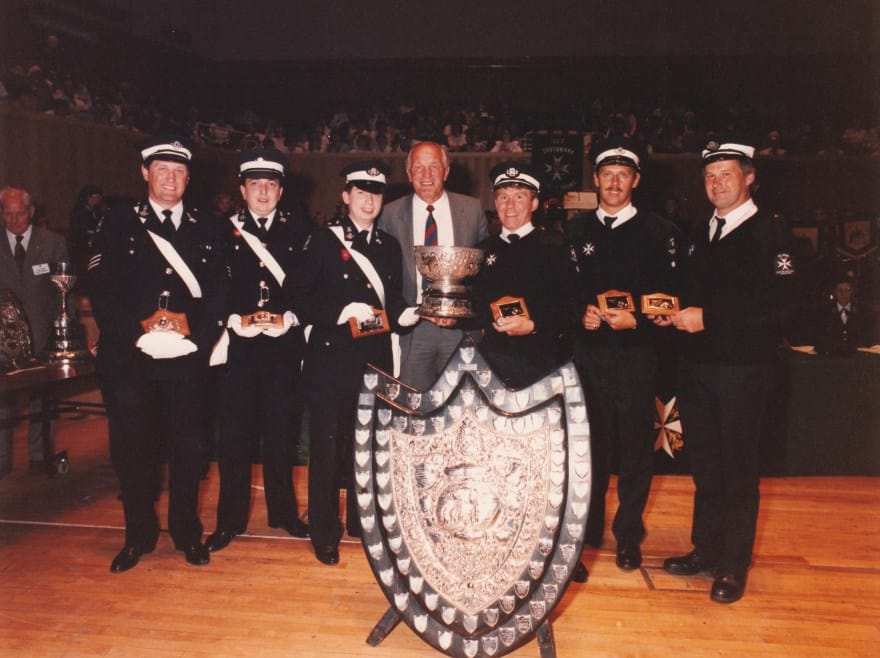 The boxer, Henry Cooper, with members of the No. 37 Paddington Borough Ambulance Division and a Doncaster Ambulance Division, winners at Brigade Finals first aid competitions, 1989 (Archive ref: PHO3370) 
